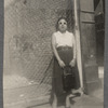 Teresa Garcia Roldan, with handbag, standing by fence, c. 1940s