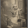 Young woman in feathered headgear and pearls in formal portrait