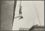Harry Houdini suspended upside down from a building