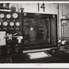 At the testing chamber for motors at the Pratt and Whitney Aircraft Corporation. After the engine is set up inside the chamber the door is sealed tight and the engine run at full blast for hours on end as an engineer watches it thru the window, records