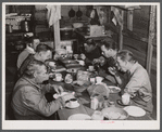 Migratory workers from Fort Bragg eating supper at a trailer settlement in Manchester, North Carolina.