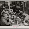 Migratory workers from Fort Bragg eating supper at a trailer settlement in Manchester, North Carolina.