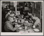 Migratory workers from Fort Bragg eating supper at a trailer settlement in Manchester, North Carolina.