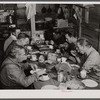Migratory workers from Fort Bragg eating supper at a trailer settlement in Manchester, North Carolina.