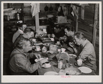 Migratory workers from Fort Bragg eating supper at a trailer settlement in Manchester, North Carolina.