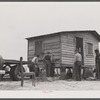 Moving a small outbuilding from the Santee-Cooper Basin by means of a trailer truck. Near Bonneau, South Carolina.