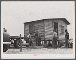 Moving a small outbuilding from the Santee-Cooper Basin by means of a trailer truck. Near Bonneau, South Carolina.