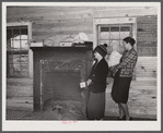 Mrs. Harvey and a neighbor watching her belongings being moved out of her house in the Camp Croft area near Whitestone, South Carolina.