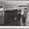 Mrs. Harvey and a neighbor watching her belongings being moved out of her house in the Camp Croft area near Whitestone, South Carolina.