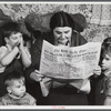 Mrs. Arthur Brown with three of her children reading Bath Daily Times. The husband works at the shipyard. After having been away from Bath for five years returned for the "Boom." Rents were too high in town and so they started building a place for