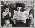 Mrs. Arthur Brown with three of her children reading Bath Daily Times. The husband works at the shipyard. After having been away from Bath for five years returned for the "Boom." Rents were too high in town and so they started building a place for