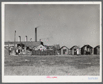 Fisherman's shacks in front of a mill along the waterfront in New Bedford, Massachusetts. Lobster traps in foreground.