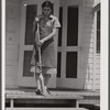 Mrs. Agnes Powell, sweeping porch of her prefabricated house at Hazlehurst Farms Inc., Hazlehurst, Georgia.
