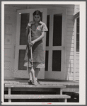 Mrs. Agnes Powell, sweeping porch of her prefabricated house at Hazlehurst Farms Inc., Hazlehurst, Georgia.