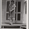 Mrs. Agnes Powell, sweeping porch of her prefabricated house at Hazlehurst Farms Inc., Hazlehurst, Georgia.