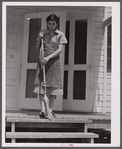 Mrs. Agnes Powell, sweeping porch of her prefabricated house at Hazlehurst Farms Inc., Hazlehurst, Georgia.