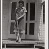 Mrs. Agnes Powell, sweeping porch of her prefabricated house at Hazlehurst Farms Inc., Hazlehurst, Georgia.