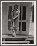 Mrs. Agnes Powell, sweeping porch of her prefabricated house at Hazlehurst Farms Inc., Hazlehurst, Georgia.
