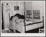 Fixing the curtains to be hung in their new prefabricated house at the home of the Hodge family. Pacolet, South Carolina.