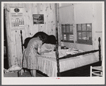 Fixing the curtains to be hung in their new prefabricated house at the home of the Hodge family. Pacolet, South Carolina.