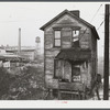 One of the houses in the [Black] quarter of Rochester, Pennsylvania. Abandoned glass works in background.