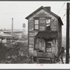 One of the houses in the [Black] quarter of Rochester, Pennsylvania. Abandoned glass works in background.
