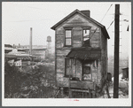 One of the houses in the [Black] quarter of Rochester, Pennsylvania. Abandoned glass works in background.