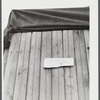 This sign was on a truck converted into living quarters at a camp for migratory workers near Fayetteville, North Carolina. It reads: "Will be back in week. Temporary lay off on acc. of material. Occupants".