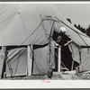 Woman living in a tent in a settlement for workers at Fort Bragg, near Fayetteville, North Carolina.