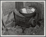 Washing dishes in a shack occupied by workers from Fort Bragg, North Carolina. Near Fayetteville.