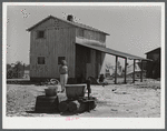 Woman fetching water. She lives with her family in lower part of the tobacco barn. Husband works at Fort Bragg. Near Fayetteville, North Carolina.