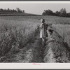 Iola Smith and her dog walking through a field on the Smith farm in Carroll County, Georgia.