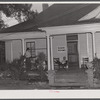 Workers from the nearby powder plant waiting for dinner on the porch of their boarding house. Childersburg, Alabama.