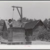Allen Mathews drawing water from his well. FSA (Farm Security Administration) borrower. Near Greshamville, Greene County, Georgia.