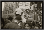 Child on protest float holding sign reading "Workers Demand Free Rent for the Unemployed!"