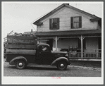 Truck load of household goods at a farm in the Pine Camp expansion area. Most farm families needed several truckloads a day to get their belongings out of the area. Near Pine Camp, New York.