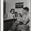 Mr. and Mrs. Carleton Allen and their daughter in the office of the New York Defense Relocation Corps discuss plans for their moving out of the area being taken over by Pine Camp. Watertown, New York.