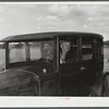 Mr. Herbert Alton, a neighbor, helps Mrs. Earl Barbour move from her home in the Pine Camp expansion area to nearby Evans Mills, New York. Alton himself will soon pack up and move to Syracuse, New York. Near Pine Camp, New York.