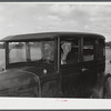 Mr. Herbert Alton, a neighbor, helps Mrs. Earl Barbour move from her home in the Pine Camp expansion area to nearby Evans Mills, New York. Alton himself will soon pack up and move to Syracuse, New York. Near Pine Camp, New York.