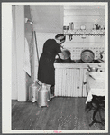 [Mrs. Gaynor at her sink, cleaning a bucket.]