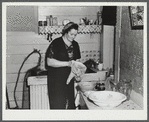 Mrs. Gaynor washing dishes on their farm near Fairfield, Vermont.