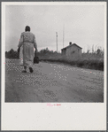 Midwife going on a call, carrying her kit, near Siloam, Greene County, Georgia.