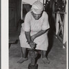 Frederiksted (vicinity), Saint Croix Island, Virgin Islands. FSA (Farm Security Administration) borrower's wife grinding corn on their farm.