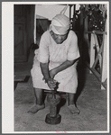Frederiksted (vicinity), Saint Croix Island, Virgin Islands. FSA (Farm Security Administration) borrower's wife grinding corn on their farm.
