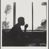 James Baldwin in silhouette sipping from glass