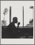 James Baldwin in silhouette sipping from glass