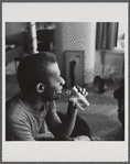 James Baldwin drinking from glass