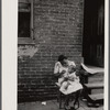 Negro family in front of their alley dwelling. The older woman is a cleaning woman in the U.S. government. Washington, D.C.