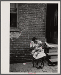 Negro family in front of their alley dwelling. The older woman is a cleaning woman in the U.S. government. Washington, D.C.