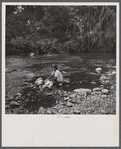 Washing clothes in the river. This is common practice in all rural areas. Puerto Rico.